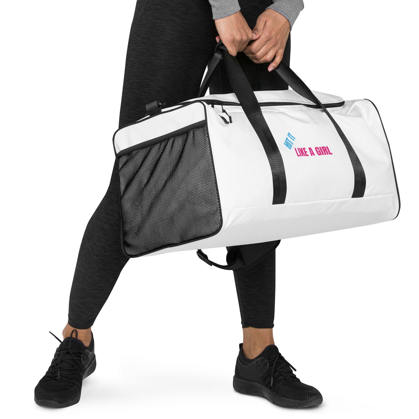 Athletic woman holding white Hit It Like A Girl duffel bag with mesh side pocket and bold black handles