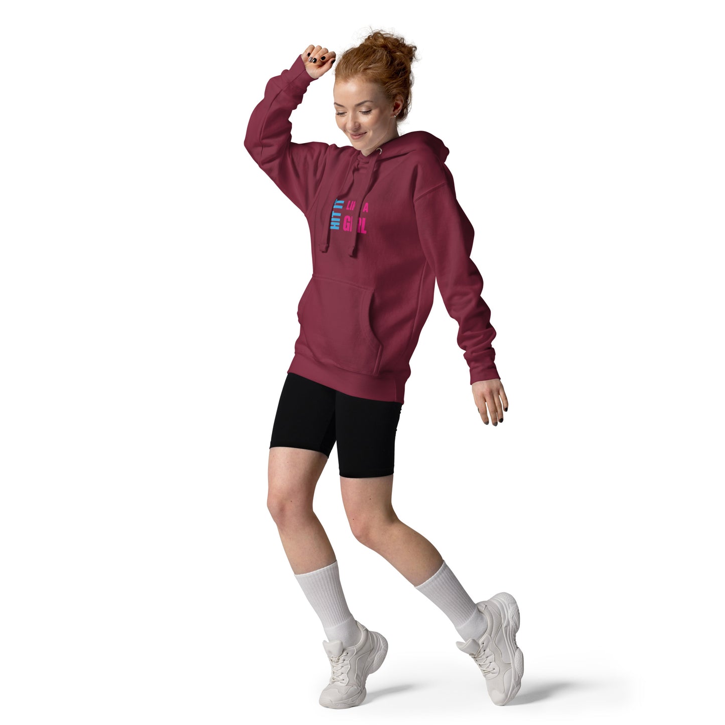 “Hit It Like a Girl” pink hoodie worn by redhead woman mid-motion — confident and cozy activewear for strong, stylish athletes.