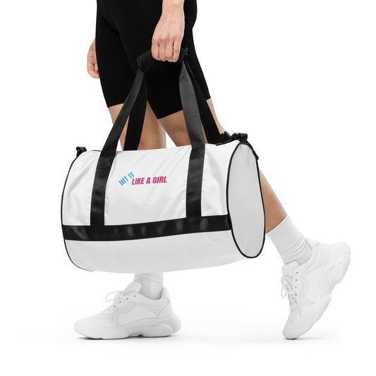 White duffel bag with black straps and ‘Hit It Like a Girl’ logo—durable and stylish gym bag for confident female athletes.
