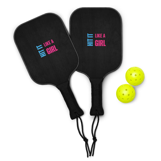 Black Hit It Like a Girl pickleball paddles with pink and blue logo, paired with two neon yellow balls — bold set for confident, competitive play.