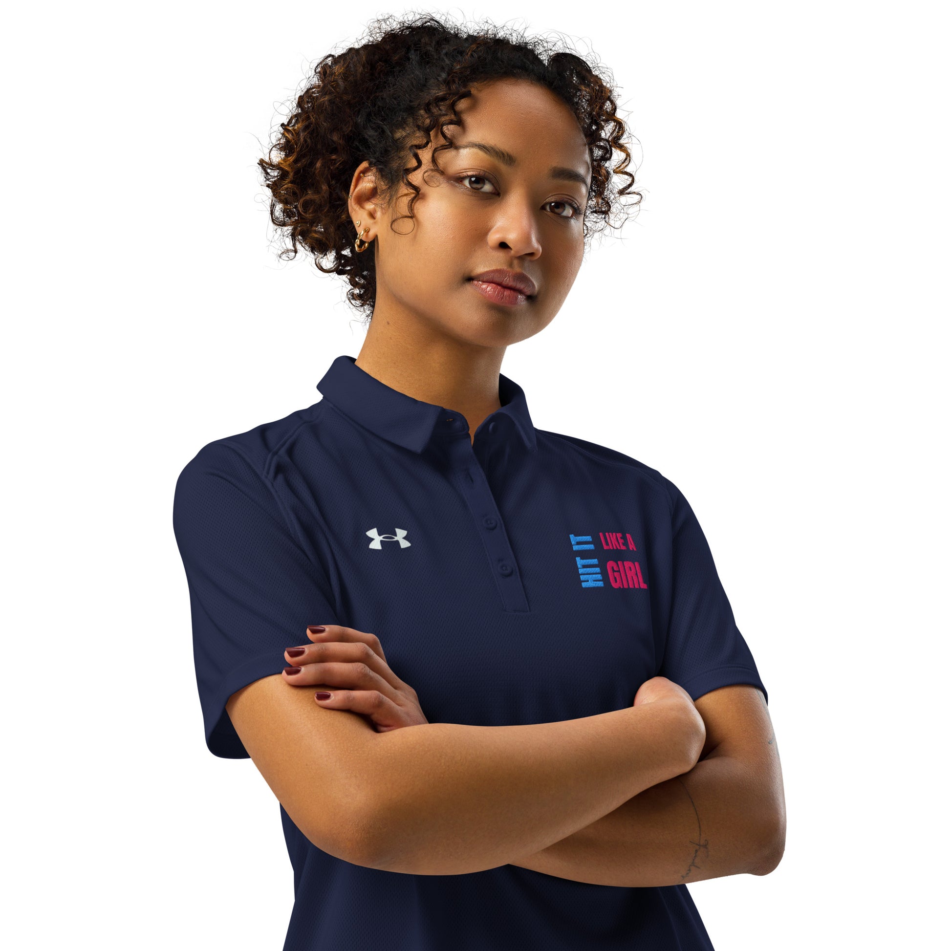 Confident woman wearing navy blue Under Armour polo shirt with “Hit It Like a Girl” logo, showcasing athletic-inspired empowerment and sporty style.