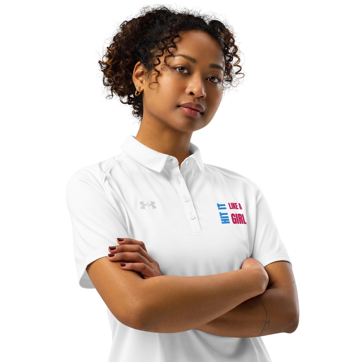 Confident woman wearing white Under Armour polo shirt with “Hit It Like a Girl” logo, showcasing athletic-inspired empowerment and sporty style.