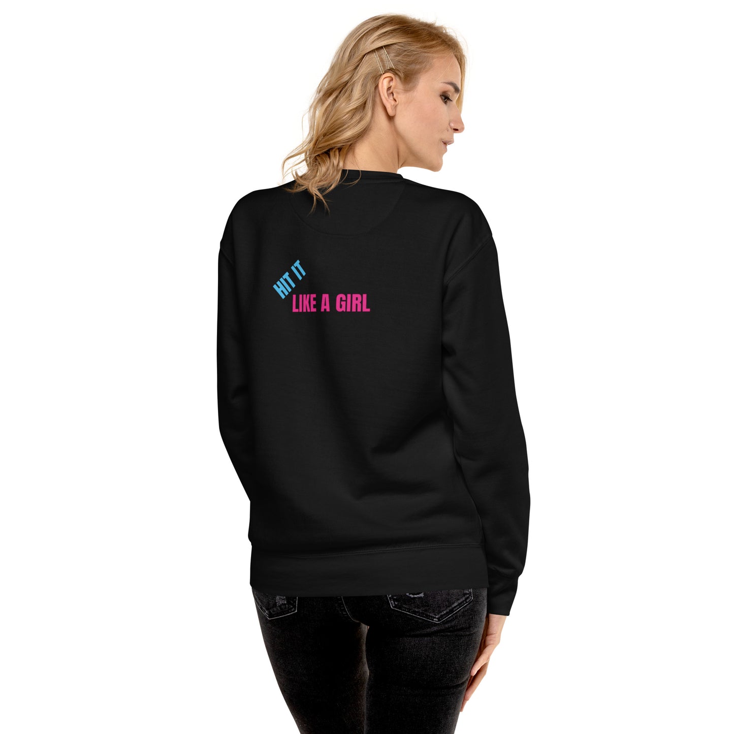 Back view of a blonde woman wearing a black fleece sweatshirt featuring the bold "Hit It Like a Girl" logo in blue and pink, with product quality callouts including tightly knit 3-end fleece, double-needle stitched details, and premium fabric features.